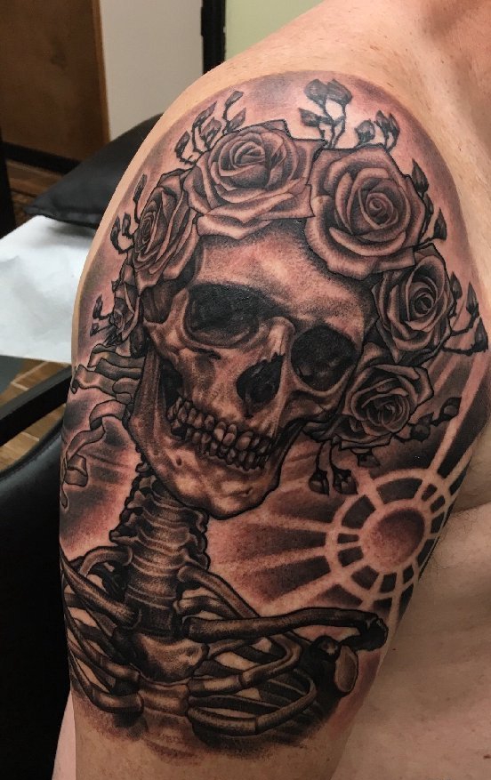 男子右手大臂膀上的黑灰色玫瑰花骷髅头纹身图片